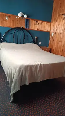 a bedroom with a large bed with a blue wall at Depto en planta alta in Villa Carlos Paz