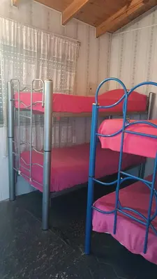 two bunk beds in a room with red and pink sheets at Depto en planta alta in Villa Carlos Paz