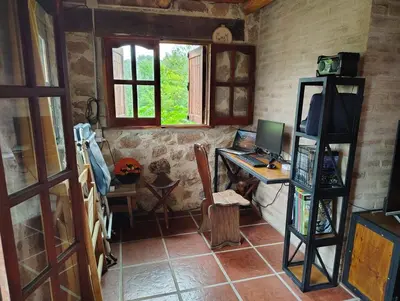 a room with a desk with a computer and a window at Stone Cabin, PETRA HAUS in Cuesta Blanca