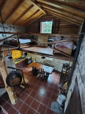 an attic room with bunk beds and a table at Stone Cabin, PETRA HAUS in Cuesta Blanca