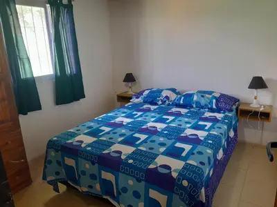 a bedroom with a bed with a blue and white quilt at Cabañas Margaret in Santa María