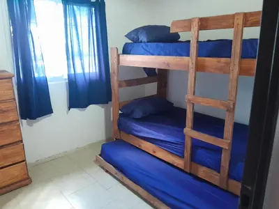 a room with two bunk beds with blue sheets at Cabañas Margaret in Santa María