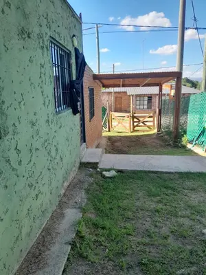 a green building with a gate and a fence at Cabañas Margaret in Santa María
