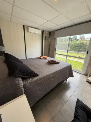 a large bed in a room with a large window at Piedras Moras cabañas in Almafuerte