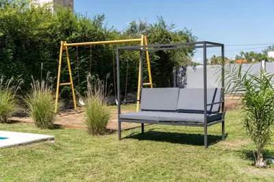 a swing seat in a yard with a playground at Piedras Moras cabañas in Almafuerte