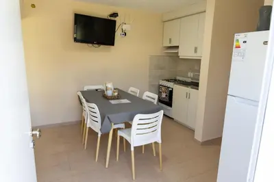 a kitchen with a table and chairs and a refrigerator at Piedras Moras cabañas in Almafuerte