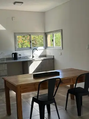 a kitchen with a wooden table and two chairs at Loft en Villa belgrano in Cordoba