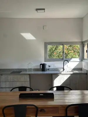 a kitchen with a wooden table and some chairs at Loft en Villa belgrano in Cordoba