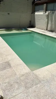 a swimming pool with blue water in front of a building at Loft en Villa belgrano in Cordoba