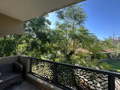 a balcony with a chair and trees in the background at Loft en Villa belgrano in Cordoba