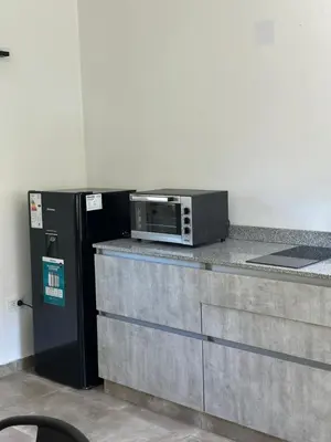 a microwave sitting on top of a counter next to a refrigerator at Loft en Villa belgrano in Cordoba