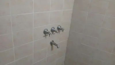 a shower with four knobs on a tile wall at Sierras de Córdoba in Santa María