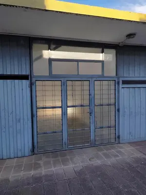 a building with three garage doors and a window at Complejo MIAMI BEACH in Villa Carlos Paz
