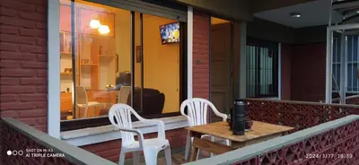 two white chairs and a table on a balcony at Complejo MIAMI BEACH in Villa Carlos Paz
