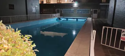 a large swimming pool with blue water in a building at Complejo MIAMI BEACH in Villa Carlos Paz