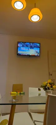 a room with a glass table and a television on the wall at Complejo MIAMI BEACH in Villa Carlos Paz