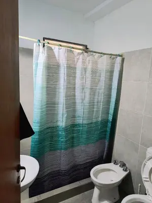 a bathroom with a shower curtain and a toilet at San Martin 40 in Villa Carlos Paz