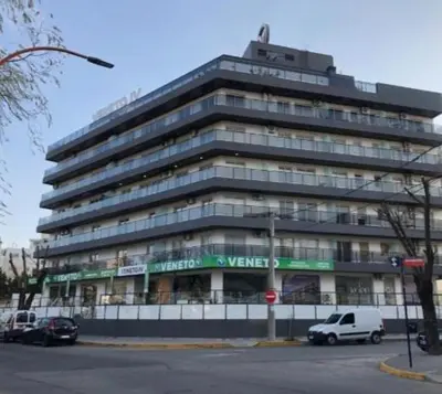a large building with cars parked in front of it at Venetto IV in Cordoba