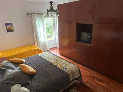 a bedroom with a bed and a dresser and a television at CASA DE CAMPO con bajada al rio in Villa Los Aromos