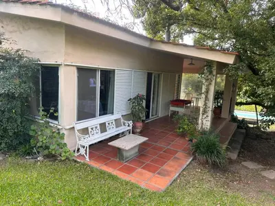 a house with a porch with a bench on it at CASA DE CAMPO con bajada al rio in Villa Los Aromos