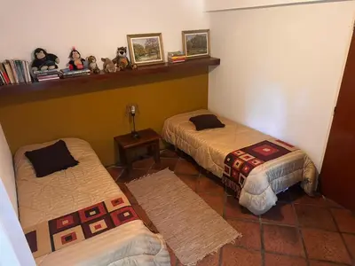 a room with two beds and stuffed animals on a shelf at CASA DE CAMPO con bajada al rio in Villa Los Aromos