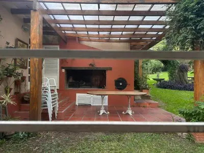 a patio with a table and a fireplace at CASA DE CAMPO con bajada al rio in Villa Los Aromos