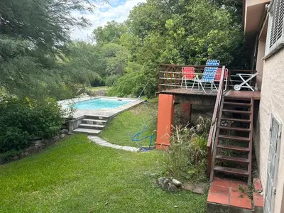 a deck with two chairs and a swimming pool at CASA DE CAMPO con bajada al rio in Villa Los Aromos
