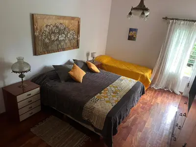 a bedroom with a bed and a dresser and a window at CASA DE CAMPO con bajada al rio in Villa Los Aromos
