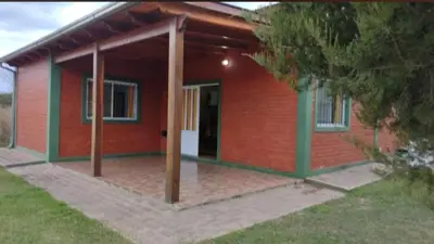 a red brick house with an open door at Cabañas Los Dos Talas in Barrio Parque El Corcovado