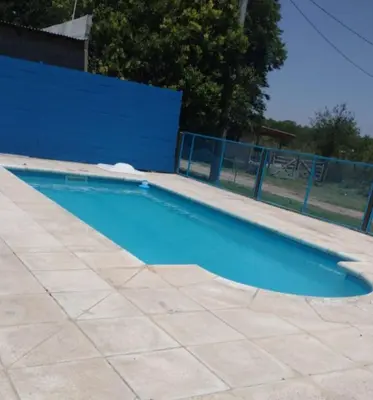 an empty swimming pool with a blue fence at Cabañas Los Dos Talas in Barrio Parque El Corcovado