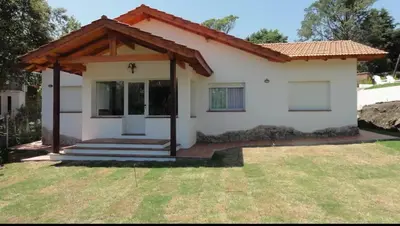 a small white house with a porch at Casa D'amico in Villa General Belgrano
