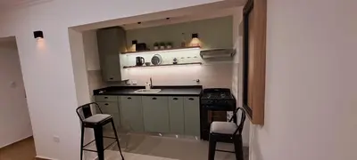 a kitchen with a sink and a stove and chairs at Mozzafiato in Cordoba