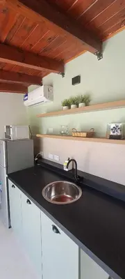 a kitchen counter with a sink and a refrigerator at Mozzafiato in Cordoba