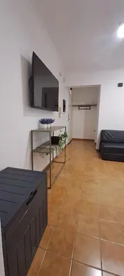 a living room with a couch and a tv on the wall at Mozzafiato in Cordoba