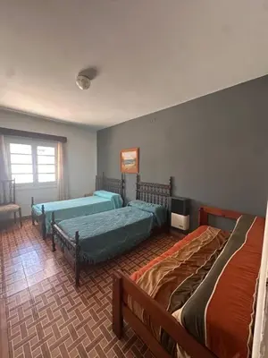 a bedroom with two beds and a tv in it at Casa del centro in Villa del Dique