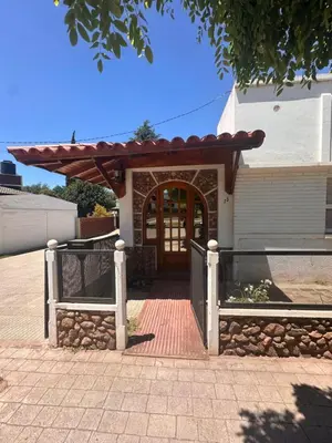 a house with a wooden door and a fence at Casa del centro in Villa del Dique