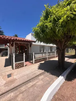 a tree in front of a white building at Casa del centro in Villa del Dique