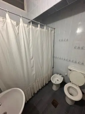 a white bathroom with a toilet and a sink at Casa del centro in Villa del Dique