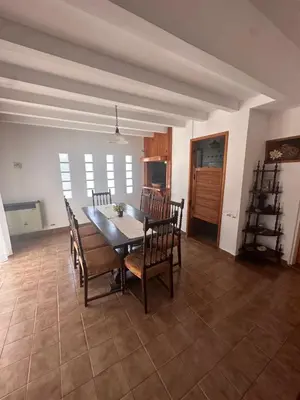 a dining room with a wooden table and chairs at Casa del centro in Villa del Dique