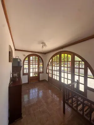 a large room with arched windows and a staircase at Casa del centro in Villa del Dique
