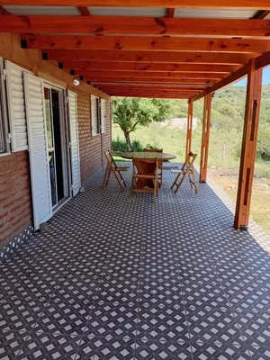 a patio with a table and chairs on it at Angel Alpino Cabin in Cuesta Blanca