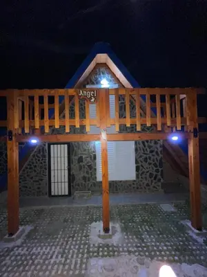 a wooden deck in front of a building at night at Angel Alpino Cabin in Cuesta Blanca