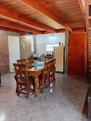 a dining room with a wooden table and chairs at Angel Alpino Cabin in Cuesta Blanca
