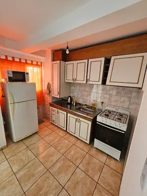 a kitchen with a white refrigerator and a stove at La Rioja Apartamento in Cordoba