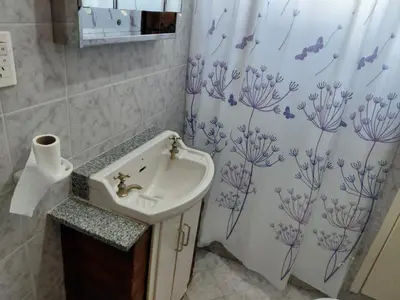 a bathroom with a sink and a shower curtain at familia olivares in Villa Carlos Paz