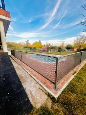 a fence around a tennis court in a park at Mirador Rest House - Casa entera con pileta privada in Bialet Massé
