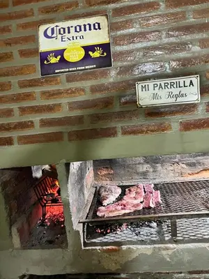 a brick wall with a grill with meat on it at Mirador Rest House - Casa entera con pileta privada in Bialet Massé
