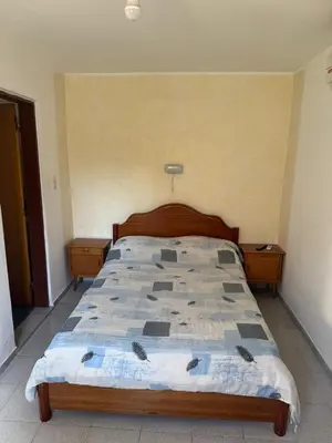 a bedroom with a bed with a wooden head board at Cabañas con pileta y aire acondicionado empalme in Villa Carlos Paz