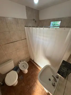 a bathroom with a toilet and a sink and a shower at Cabañas con pileta y aire acondicionado empalme in Villa Carlos Paz
