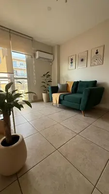 a living room with a green couch and a potted plant at Güemes Apartamento in Cordoba